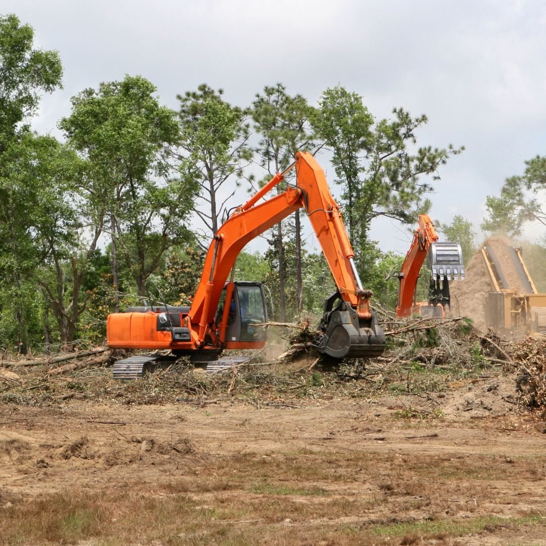 Excavator clearing brush beside a house — Tree removal in Lowell, IN