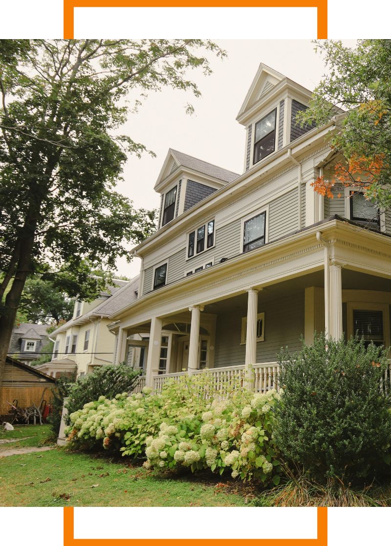 a large home with a tree in the front yard